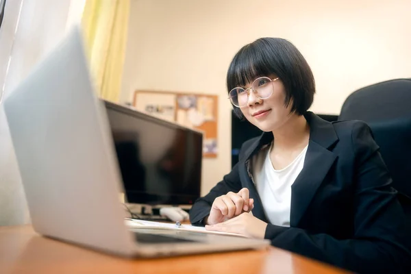 Young adult asian woman stay and work from home office concept. Female using laptop computer for video call meeting conference via internet online. Indoor life with technology on day.
