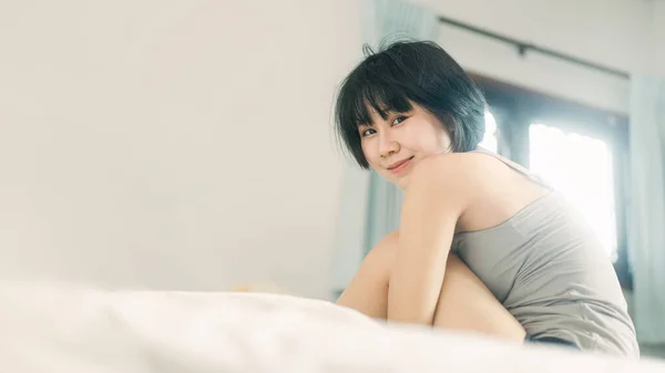 肖像幸せな笑顔若い大人のアジアの女性 女性は朝起きてから寝室でリラックスします カメラを見る目 — ストック写真