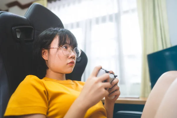 オタクスタイルの若い大人のアジアのゲーマーの女性は眼鏡をかけてオンラインゲームをプレイします 勝利気分のための競争 家庭での余暇生活 — ストック写真