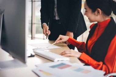 Teknolojiyle birlikte yetişkin Asya işi. Fikir için ekiple birlikte iş kadını beyin fırtınası. Üzerinde bilgisayar ve kağıt olan bir çalışma masası. En az ofis penceresi ışığı arkaplanı.