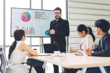 Güneydoğu Asya İş Adamları Grubu ofis konsepti üzerinde çalışıyor. CEO 'su sakallı adam sunum yapıyor ve toplantı odasında ekiple kısa bir strateji kuruyor..