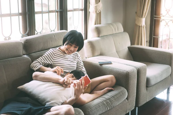 若い大人のアジアの恋人のカップルが一緒に自宅の概念で生活している 幸せな笑顔の人々のソファ居心地の良いスタイルの屋内で1日に座っている 窓光の背景 — ストック写真