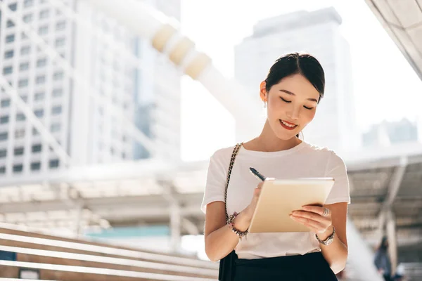 Genç yetişkin işleri Asyalı kadın interaktif dijital tablet üzerinde çalışıyor. Modern teknolojiyle yaşam tarzı. Bekar girişimci iş kadını görünüşü.