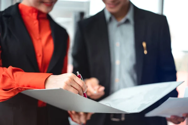 Young business staff asian man and woman. Employee corporate assistant work project as a teamwork. Her hand holding a pen and writing.