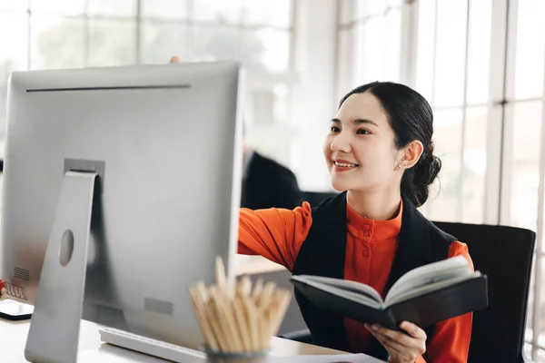 Portrait of happy smile office business asian salary woman. Workplace with document and computer. She write a start project on a desk. Background with window light.