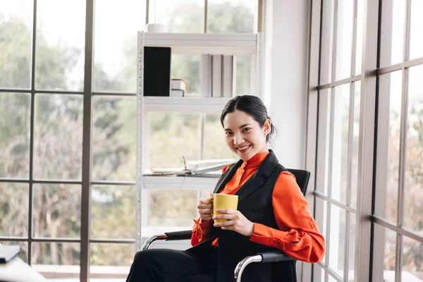 Relax office business asian elegant woman. Businesswoman take a break drink coffee office with window light. Minimal modern workplace office background.