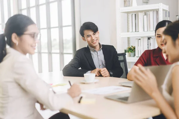 Focus on man entrepreneur. Southeast asian Business people group coworker working in office concept. Men sitting and discussion strategy with team in boardroom.