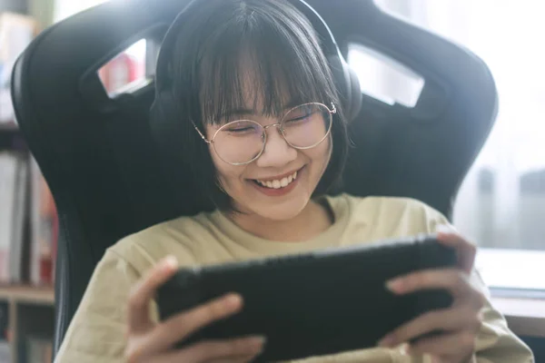 オタクスタイルの若い大人のアジアのゲーマーの女性は眼鏡を着用し ヘッドフォンはオンラインゲームをプレイします 勝利気分のための競争 家庭での幸せな人々のレジャーライフスタイル — ストック写真