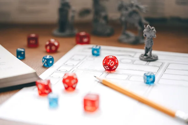 Role playing tabletop and board games hobby concept. D12 dice place on character sheets for create begin fantasy and adventure. Background with book and miniatures.