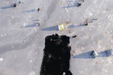 Buzda kış balıkçılığı yukarıdan bakıldığında, pek çok donanımlı balıkçı balıkçılıkla meşgul..