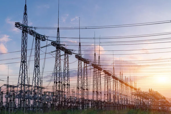 Gün batımında elektrik direkleri ve doymuş güzel gökyüzü. dağıtım, iletim ve elektrik tüketimi