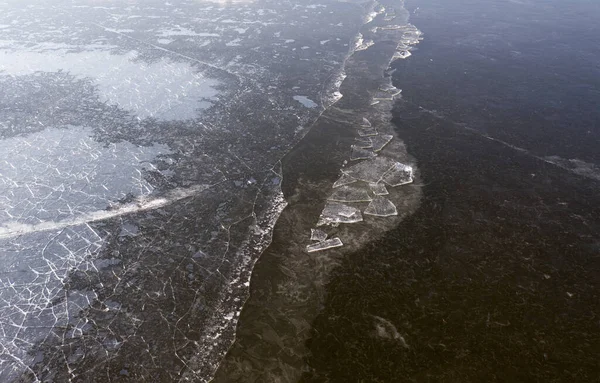 壊れた白氷と濃い青の水の抽象的なテクスチャ 無人機からの氷の眺め 清らかな湖や川の凍結面の背景 — ストック写真