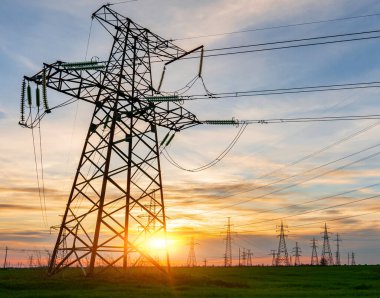 Güzel bulutlu gökyüzünün arka planında yüksek voltajlı elektrik hatları var..