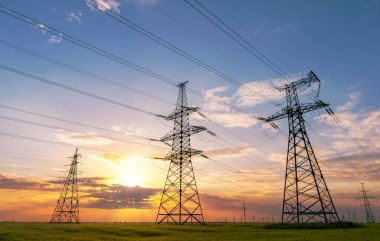 Gün batımında elektrik direkleri ve doymuş güzel gökyüzü. dağıtım, iletim ve elektrik tüketimi