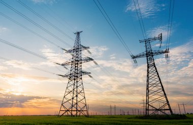 Gün batımında elektrik direkleri ve doymuş güzel gökyüzü. dağıtım, iletim ve elektrik tüketimi