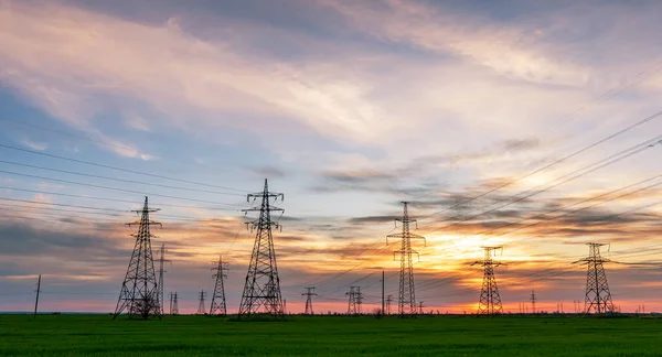 Yüksek Voltajlı Elektrik Hatlarının Silueti Gün Doğumunda Günbatımında Renkli Bir — Stok fotoğraf