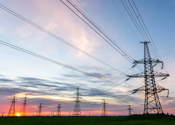 Güzel bulutlu gökyüzünün arka planında yüksek voltajlı elektrik hatları var..