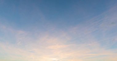 Gün batımında sirus bulutları hareket eder. Turuncunun ince tonlarında gökyüzü. Şahane ve aynı zamanda dramatik gün batımında gökyüzü