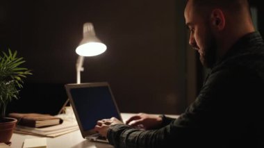 Night Work. Typing a Message on the Laptop.