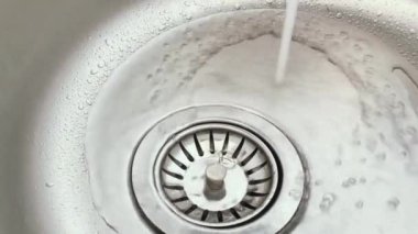 Kitchen Gadgets. Water in the Kitchen Sink. Water is flowing from the Tap.