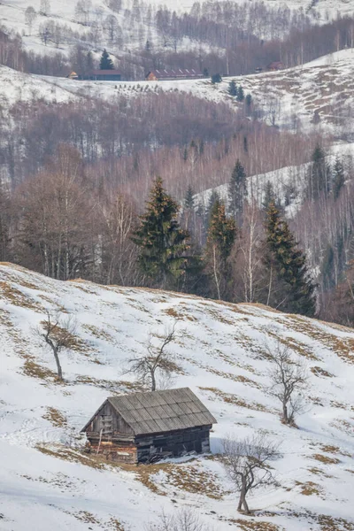 Eski bir ev ve arkasında Bucegi dağları olan kış manzarası. Transilvanya 'da Drakula' nın şatosu ve Karpatya dağları yakınlarındaki bir köyde.