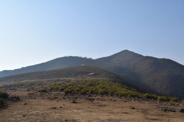 Dağları ve mavi gökyüzü olan güzel bir manzara.