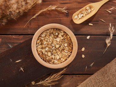 Oat flakes, rolled oats in wooden bowl 