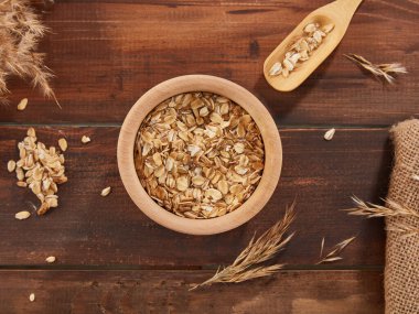 Oat flakes, rolled oats in wooden bowl 