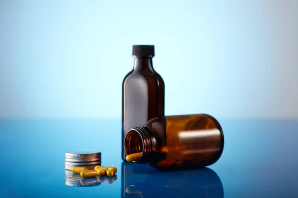 青い背景にこぼれた薬瓶 — ストック写真