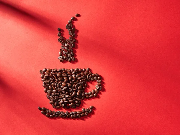 红底咖啡豆做的咖啡杯形状 — 图库照片