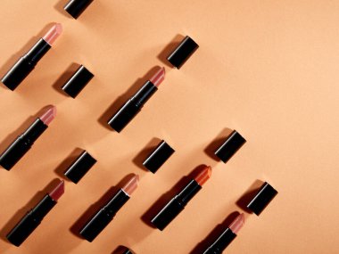 Portakal rengi arka planda kozmetik ürünlerinin yaratıcı desenli bir fotoğrafı.