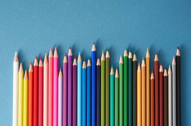 mavi arkaplanda renkli kalemler.