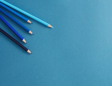 Arkaplanda renkli kalemlerin düz resim, mavi arkaplanda kırtasiye