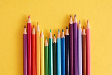 Sarı arkaplanda renkli kalemler.