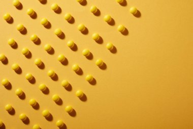 Sarı renkli kağıttan arka planda sarı çikolatalı şekerler