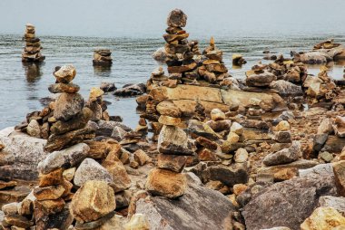 Turistler tarafından istiflenmiş taş piramitleri ilginç bir Norveç manzarası yaratır. İskandinavya, fiyort, Norveç.