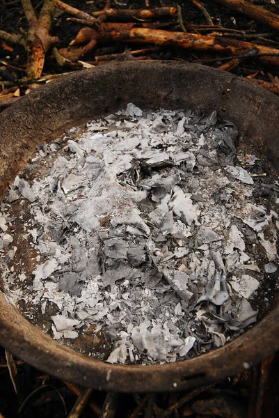 Ashes in the metal pan in which the campfire was burned. Fireplace.