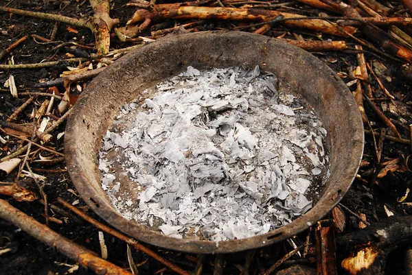 Ashes in the metal pan in which the campfire was burned. Fireplace.