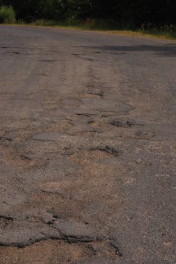 Yoldaki delik. Kırık asfalt. Yok edilmiş yüzey. Çatlak yol.