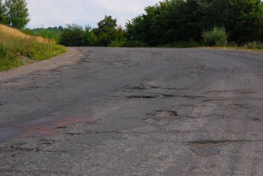 Yoldaki delik. Kırık asfalt. Yok edilmiş yüzey. Çatlak yol.