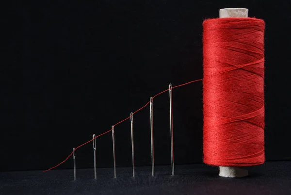 growth graph as a red thread passed through a sewing needle to a spool