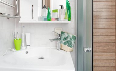 lavabo ve musluk modern banyo içi akan suyla, diş fırçaları kozmetikle