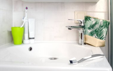 lavabo ve musluk modern banyo içi akan suyla, diş fırçaları kozmetikle