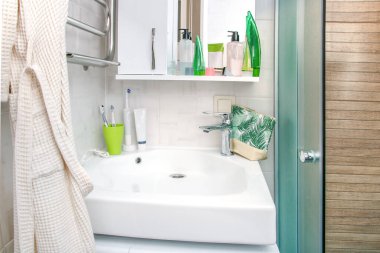 İçinde lavabo ve bir bardak su olan modern bir banyo.