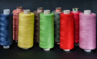 Beyaz arkaplanı dikmek için renkli iplikler