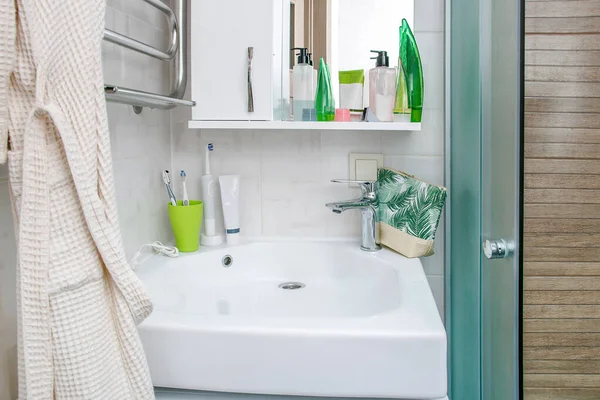 lavabo ve musluk modern banyo içi akan suyla, diş fırçaları kozmetikle