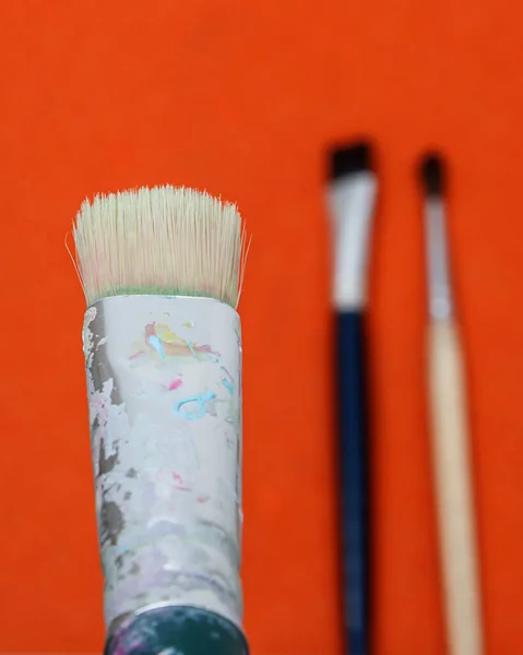 paint brushes in a jar on a white background