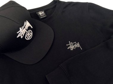 Malang, Endonezya - 10 Haziran 2022: tişört ve şapkada Stussy logosu. Stussy bir sokak giyimi markası.