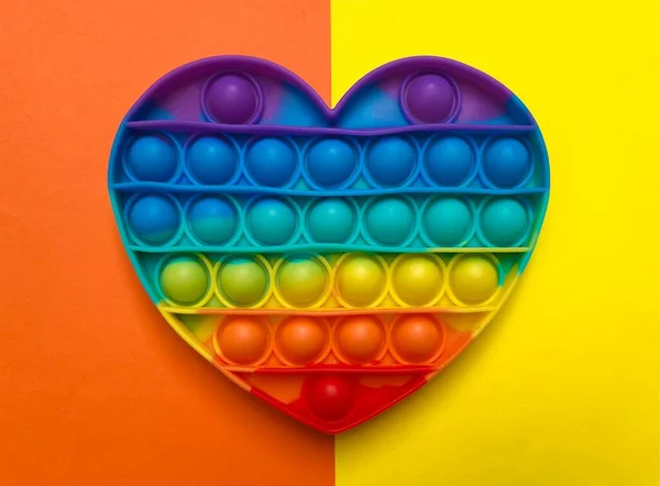 A Pop it rainbow heart shaped toy, this popular fingertip fidget toy is a stress and anxiety relief sensory toy.