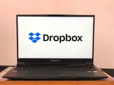 Malang, Indonesia - May 19th 2022: Dropbox logo displayed on laptop computer screen, Dropbox is a private cloud storage service often used for file sharing and collaboration. clipart